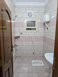 ein Bad mit einem Waschbecken und einem TV an der Wand in der Unterkunft شقق مفروشة in Medina
