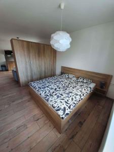 a bedroom with a large bed with a wooden floor at DomirexGroup Apartments in Lučenec