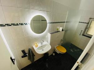 ein Badezimmer mit einem Waschbecken, einem WC und einem Spiegel in der Unterkunft Charming Apartments l 7 Beds l 4 Bedrooms l WI-FI in Geseke