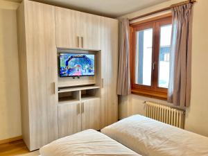 una camera con TV, letto e finestra di Chalet Rododendro a Livigno