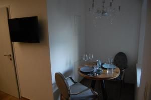 a dining room table with two chairs and a chandelier at myQuartier - Central City DeLuxe Apartments in Innsbruck