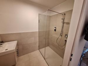 a shower with a glass door in a bathroom at myQuartier - Central City DeLuxe Apartments in Innsbruck
