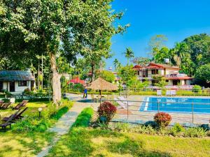 un complejo con piscina y casa en Hotel Hermitage, en Sauraha