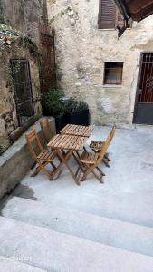 drewniany stół i dwa krzesła obok budynku w obiekcie La Chicca Maison w mieście Vercurago