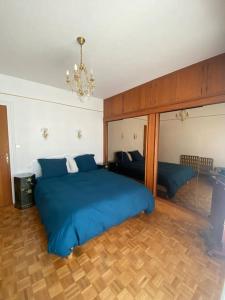um quarto com uma grande cama azul e um sofá em Villa 4* Proche centre et plage. Animaux bienvenus em Meschers-sur-Gironde