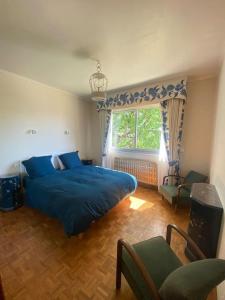una camera da letto con un letto blu e una finestra di Villa 4* Proche centre et plage. Animaux bienvenus a Meschers-sur-Gironde