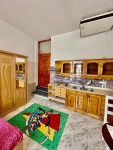 uma cozinha com armários de madeira e um tapete verde em Palma de Meritee villa 2 apartment 4 village veiw em Hurghada