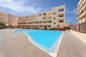 een zwembad voor een appartementencomplex bij Apartamento El Médano Marineda in Granadilla de Abona