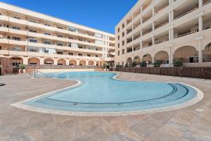 una piscina di fronte a un grande edificio di Apartamento El Médano Marineda a Granadilla de Abona
