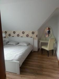a bedroom with a bed and a desk and a mirror at Pension Klarissa in Sovata