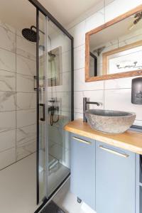 La salle de bains est pourvue d'un lavabo et d'une douche en verre. dans l'établissement Deluxe House Maj, à Brežice