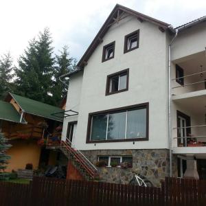 a white house with black windows and a fence at Pension Klarissa in Sovata