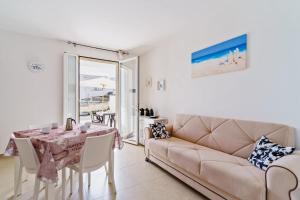 ein Wohnzimmer mit einem Sofa und einem Tisch in der Unterkunft Casa d'a mare in Torre San Giovanni Ugento