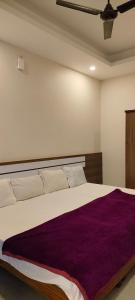 a bedroom with a large bed with a purple blanket at Remarita Holidays in Panamaram