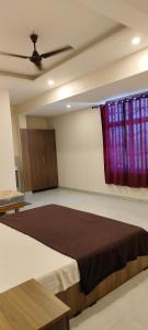um quarto com uma cama grande e cortinas roxas em Remarita Holidays em Panamaram