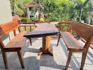 een picknicktafel en twee banken op een patio bij Nuree Villa in Phra Ae beach