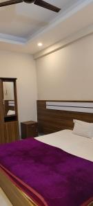 um quarto com uma cama grande e um cobertor roxo em Remarita Holidays em Panamaram