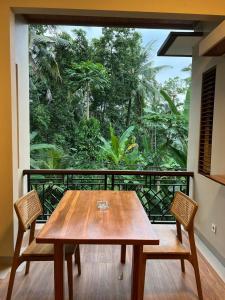 un tavolo in legno e 2 sedie sul balcone di Rare House ad Ubud