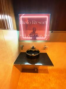 a bathroom with a black sink and a pink sign at Biafo House in Skardu