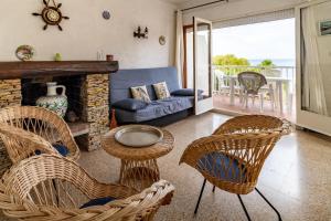 - un salon avec des fauteuils en osier et un canapé dans l'établissement Carboneres 461 - Apartamento con terraza y vistas, à Llançà