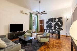 ein Wohnzimmer mit einem Sofa und einem TV in der Unterkunft ROMAC - Condotti Suite by Spanish Steps in Rom