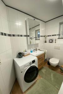 a white bathroom with a washing machine in the sink at Gemeinsame Zeit in Appenweier