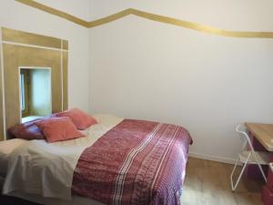 een slaapkamer met een bed met 2 kussens erop bij Le Puech et vous in Saint-André-de-Majencoules