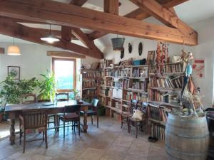 een eetkamer met een tafel en veel boekenplanken bij Le Puech et vous in Saint-André-de-Majencoules