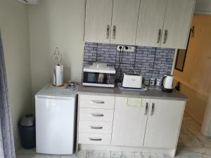 uma cozinha com um frigorífico branco e um micro-ondas em BARNES STREET BNB em Timaru