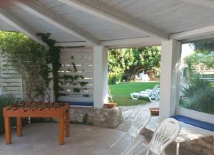 pérgola con mesa y sillas en el patio en Villa Aurea, en Ispica