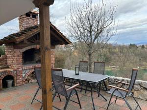 a table and chairs on a patio with a brick oven at Holiday house “The View” in Ozalj