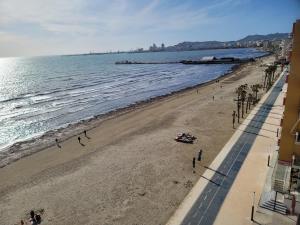een uitzicht op een strand met mensen en de oceaan bij "On the beach" Glamour Sunrise Apartment in Durrës