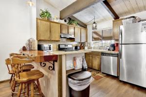 a kitchen with wooden cabinets and a stainless steel refrigerator at 2461-Smith Summit Chalet townhouse in Big Bear Lake