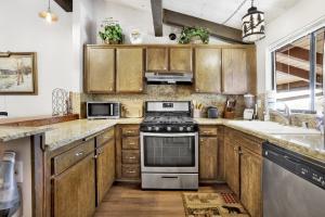 cocina con armarios de madera y horno con fogones en 2461-Smith Summit Chalet townhouse, en Big Bear Lake