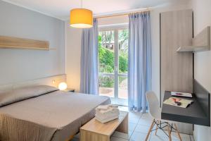 a bedroom with a bed and a table and a window at Hotel & Resort Sant'Anna Del Volterraio in Portoferraio +67 photos