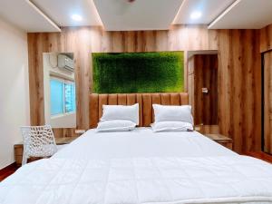 sypialnia z dużym białym łóżkiem i zielonym obrazem w obiekcie BMS Guest House - 2 BHK Lux Ac Only For Family's w mieście Hajdarabad