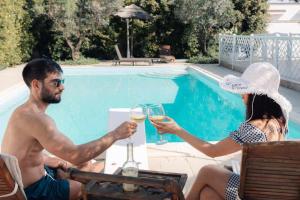 Ein Mann und eine Frau sitzen mit Gläsern Wein an einem Tisch in der Unterkunft Villa èlitè by Vivimy in Taviano