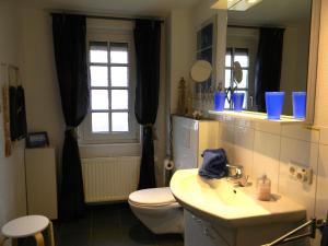 y baño con lavabo, aseo y espejo. en Haus Hallig Hooge, en Stinteck