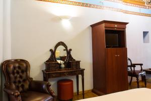 a room with a chair and a mirror and a chair at Kyveli Suites in Nafplio