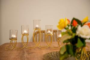 três velas sobre uma mesa com um vaso de flores em Dolce Favola Nomad Casa - Kalamata's City Getaway em Kalamata