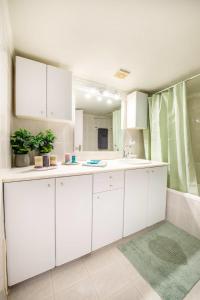 a white kitchen with a sink and a mirror at Dolce Favola Nomad Casa - Kalamata's City Getaway in Kalamata