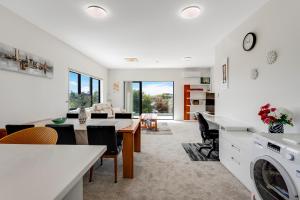 a kitchen and living room with a washer and dryer at Sleek Vista Townhouse with deck and air-con in Auckland