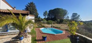 a backyard with a swimming pool and a house at L'AMBROISINE in Saint-Ambroix