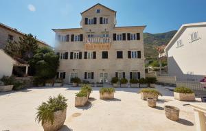 a large building with potted plants in a courtyard at Palate Verona in Prčanj +18 photos