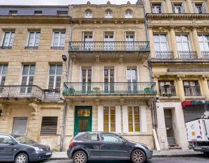 Deux voitures garées devant un grand bâtiment dans l'établissement Elegant apartment Bordeaux center, à Bordeaux