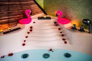 two pink flamingos sitting on top of a bath tub at Hot Jacuzzi in Cracow in Kraków