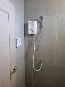 La salle de bains est pourvue d'une douche avec un pommeau de douche. dans l'établissement Rest at Thachang Hotel, à Ban Hua Han