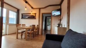 a living room with a table and chairs and a tv at Alpenzauber Tilg in Imst