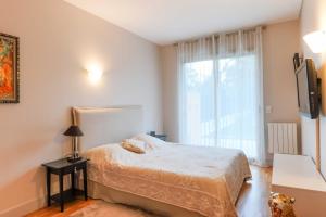 1 dormitorio con cama y ventana grande en Air-conditioned apartment with terrace Hauts de Seine, en Neuilly-sur-Seine