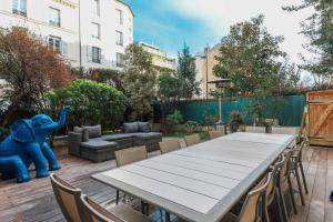 a patio with a table and chairs and a elephant statue at Air-conditioned apartment with terrace Hauts de Seine in Neuilly-sur-Seine